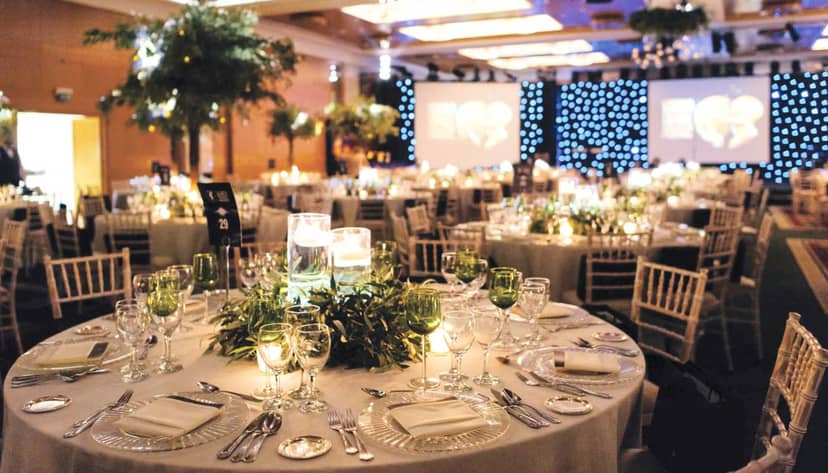 Gala setup at Foyer Olympia: elegant greenery table decor and starry-night backdrop for events.