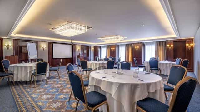 Elegant Electra Palace Athens ballroom with round tables for corporate events and gala meetings.