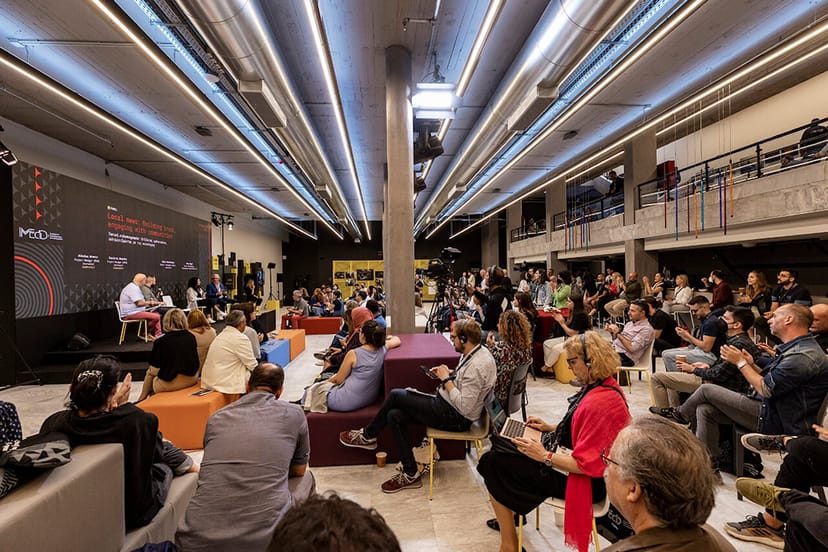 Modern tiered Arts Lounge in Athens Conservatoire for panel discussions and networking events.