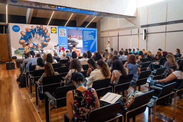 Corporate panel discussion at Athens Conservatoire featuring branded stage and theater seating.