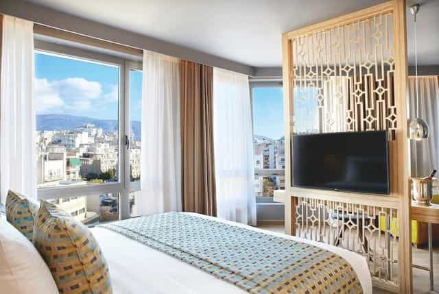 VIP guest room at Wyndham Grand Athens with panoramic city views for conference executives.