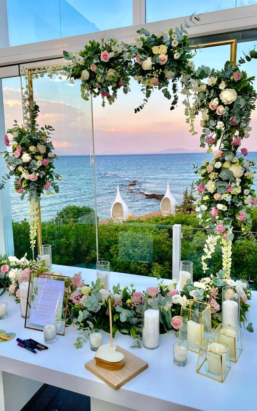 Luxury coastal wedding backdrop with floral sunset decor for premium outdoor event photography.