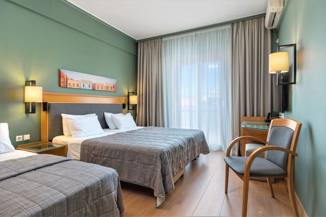 Plaka Hotel twin guest room with desk workspace for event lodging and business travel.