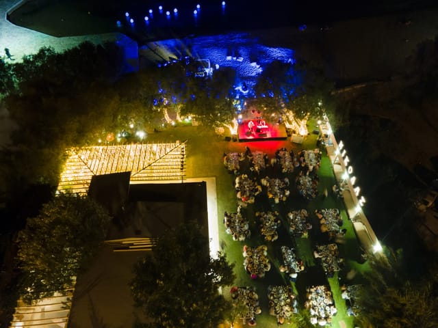 Outdoor gala at Rotundas Reef Athens Riviera with elegant uplighting and stage branding.