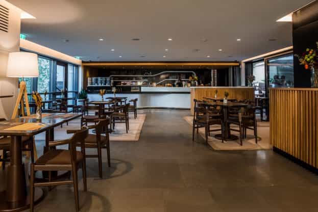 Contemporary cafe restaurant space with flexible tables for networking events and conferences.