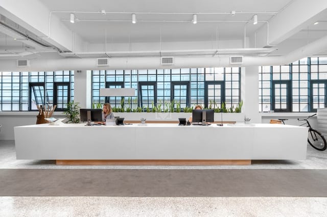 Modern coworking space reception desk for event check-in and professional business networking.