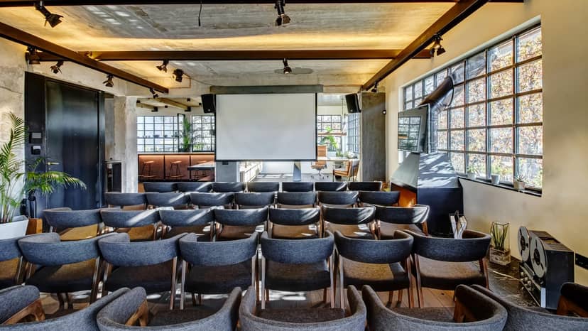Industrial-chic workshop space with stylish seating for intimate presentations and events.