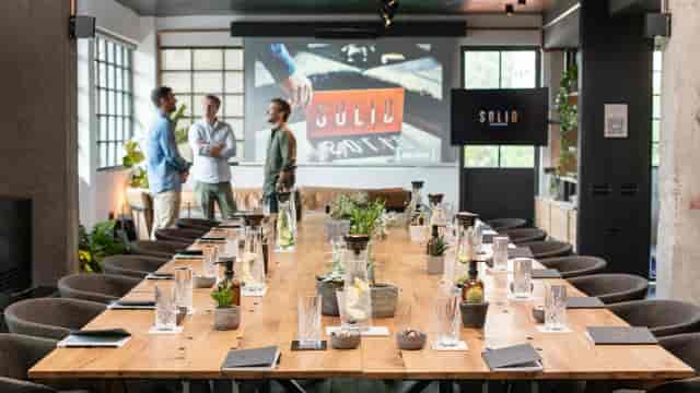 Boardroom at Loft Psychiko with wood table for corporate offsite and strategy session.
