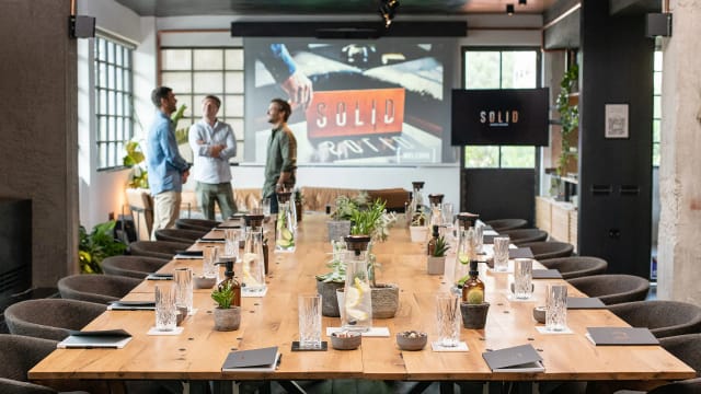 Boardroom at Loft Psychiko with wood table for corporate offsite and strategy session.