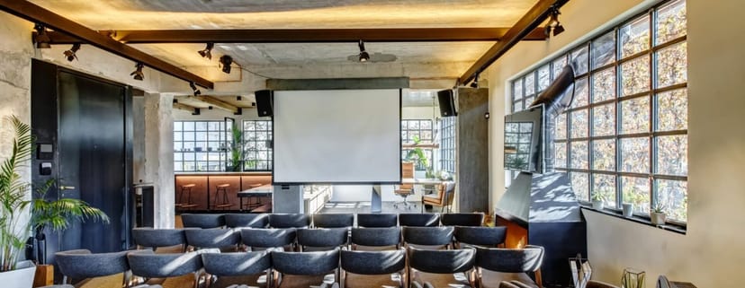 Industrial conference room with theater seating for corporate meetings and networking events.