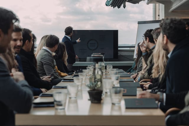 Outdoor corporate boardroom meeting at a conference table for professional event planning.