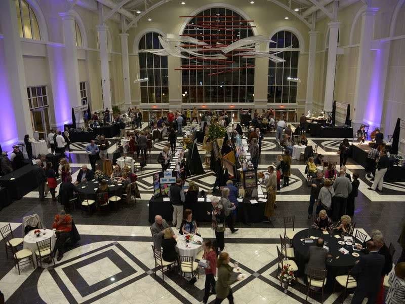 Networking reception at The Classic Center atrium with elegant uplighting and event seating.