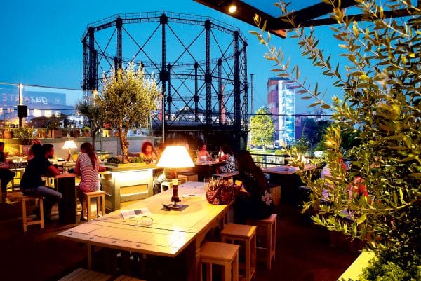 Industrial-chic rooftop lounge, Gazarte networking event with ambient table lighting.