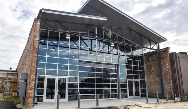 Industrial-chic event venue with glass garage door for indoor-outdoor weddings and parties.
