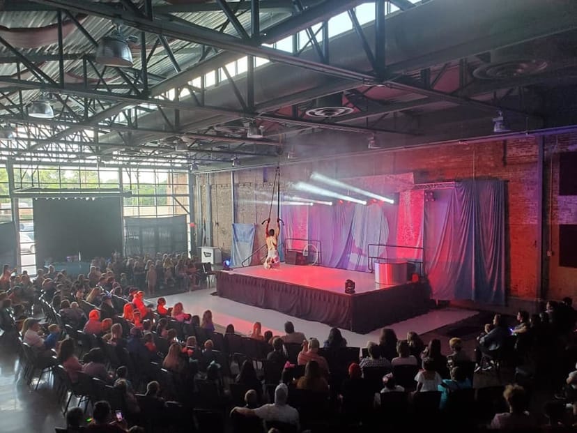 Aerial performance at The Texan industrial event venue with dramatic targeted lighting.