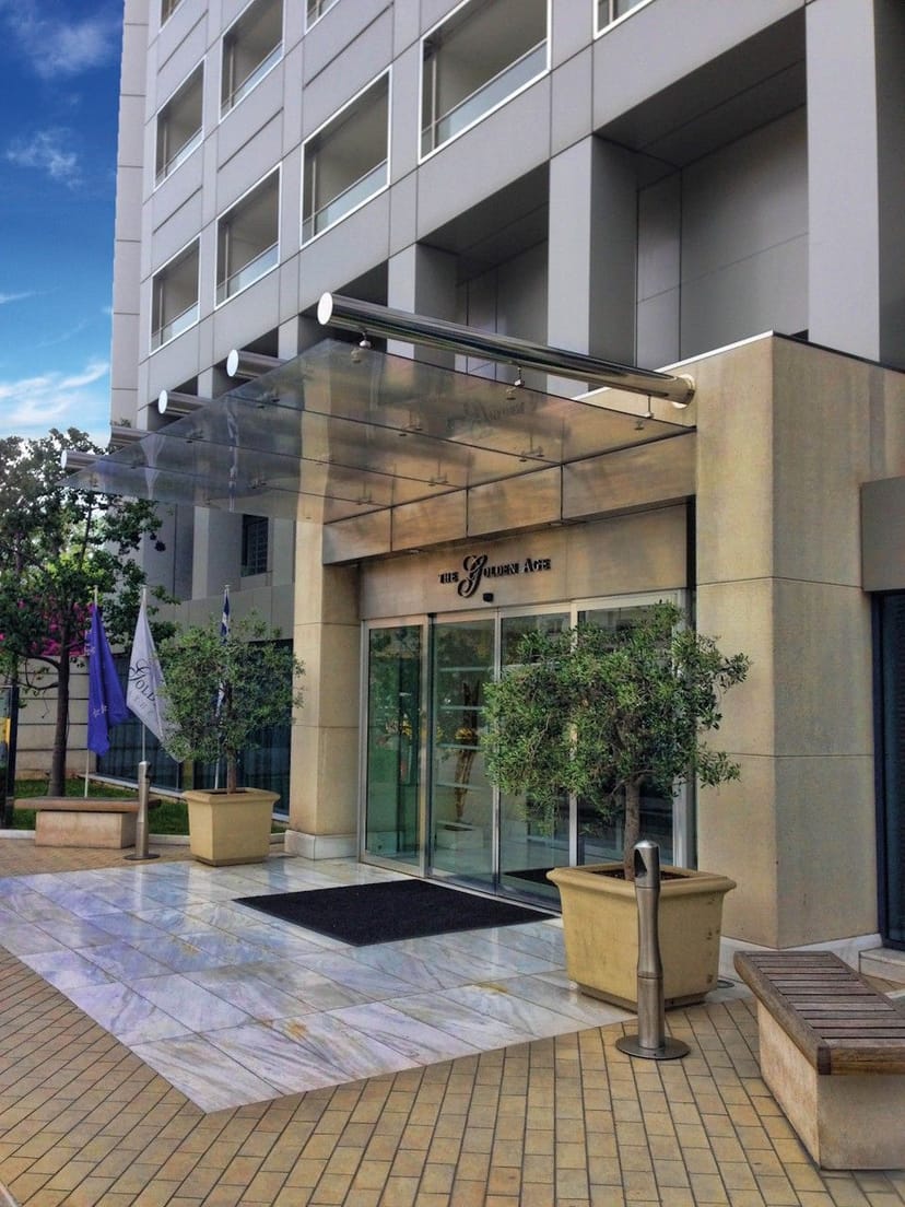Erato hotel entrance with elegant glass facade for corporate event arrival and brand promotion.