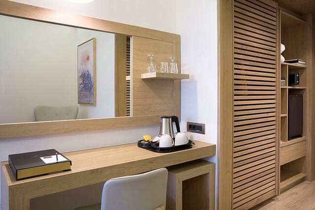 Erato Hotel minimalist guestroom workstation for business travel and professional event prep.
