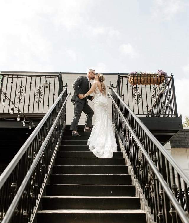 Couple on outdoor staircase at The Venue on Broad for elegant wedding photography first look.