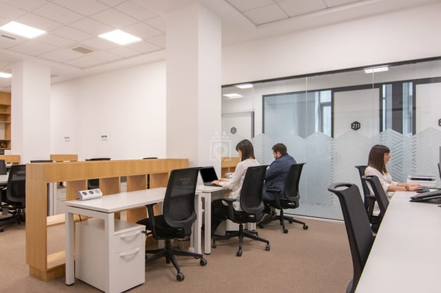 Ergonomic coworking space with glass partitions for productivity and team meetings.