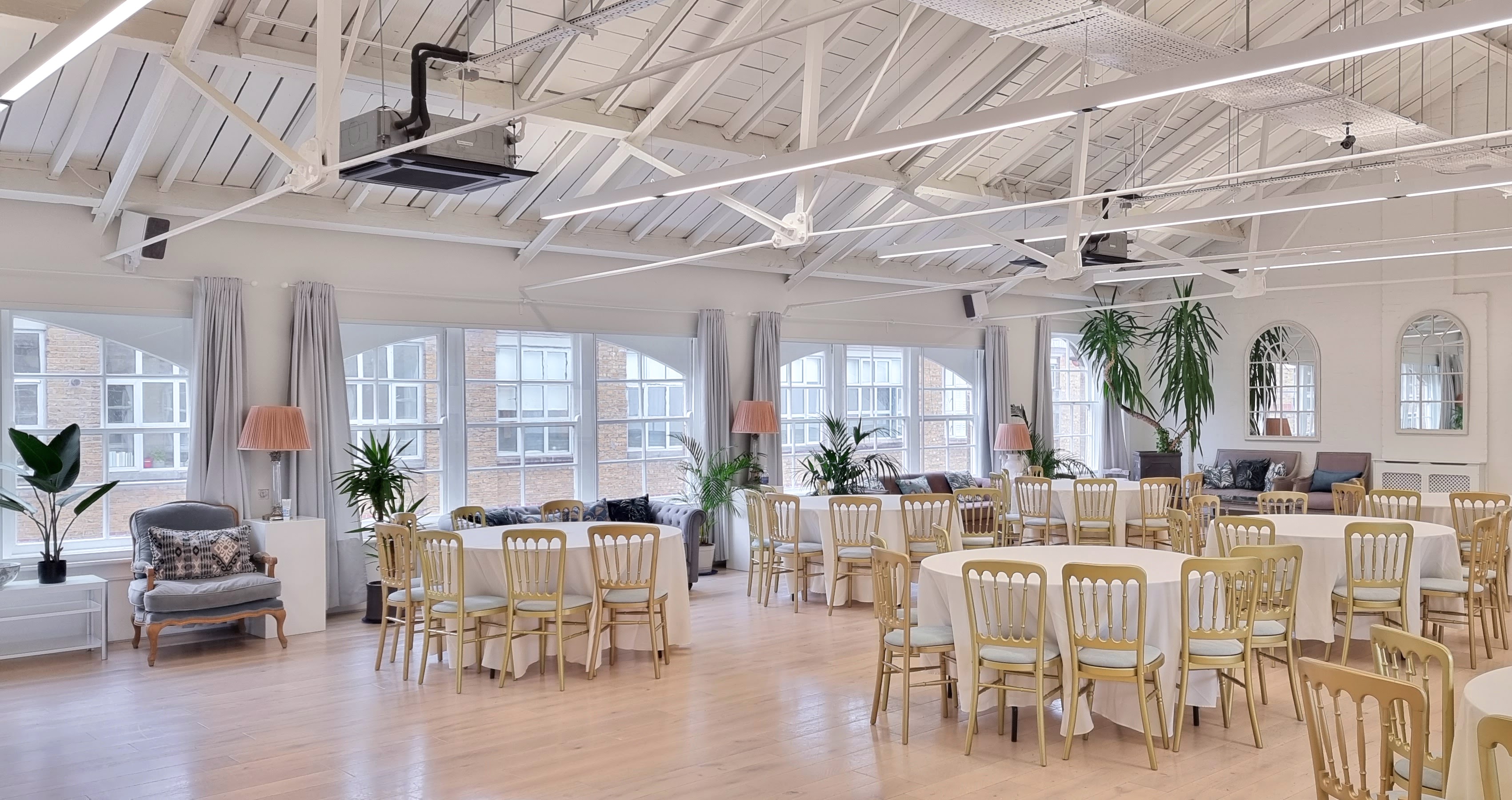 Bright event space with round tables, perfect for meetings and social gatherings.