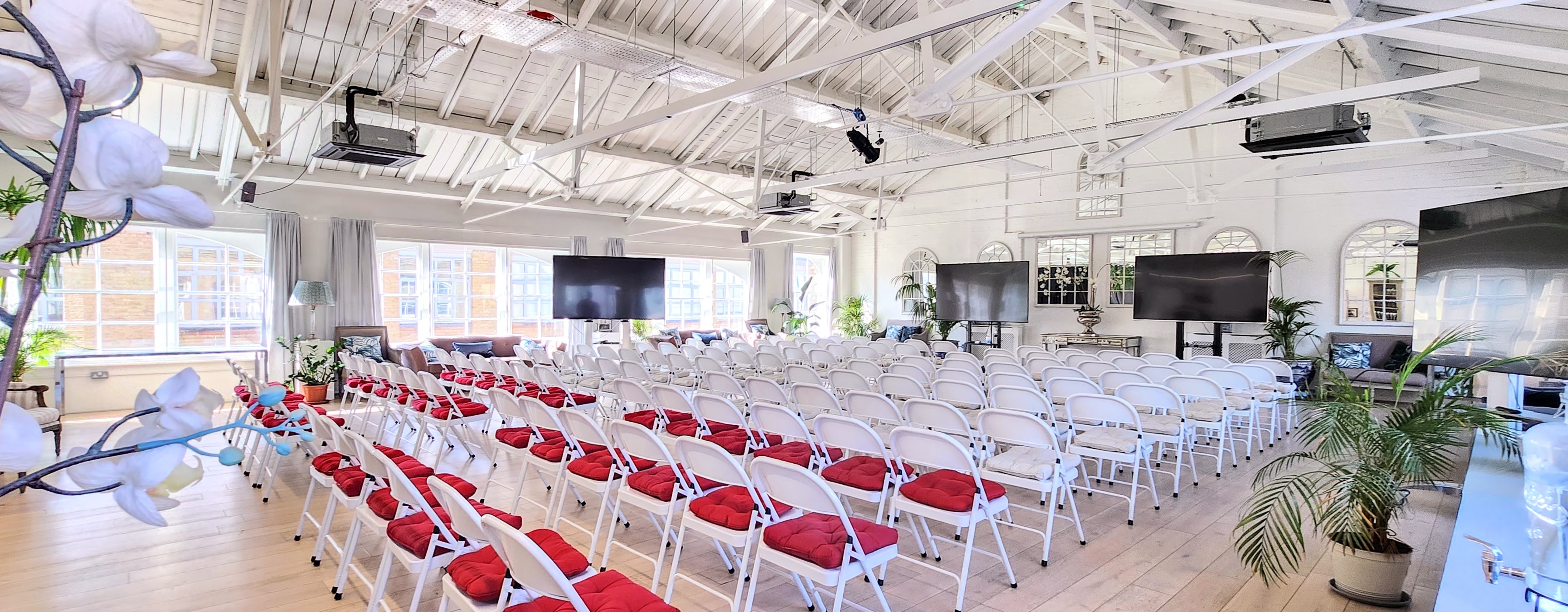 Underwood Flagship Venue with white chairs and red cushions for conferences and seminars. - Banner