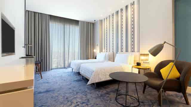 Modern twin-bed guest room at Le Méridien Riyadh for conference accommodation and business travel.