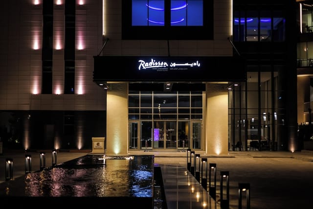 Radisson Blu Riyadh Al Sahafa evening fountain exterior for corporate events and networking.