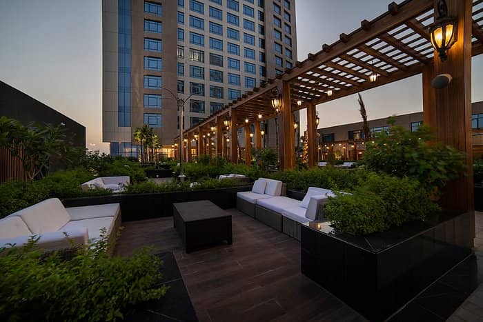 Rooftop pool lounge at Mövenpick Riyadh with pergola lighting for cocktail receptions and events.