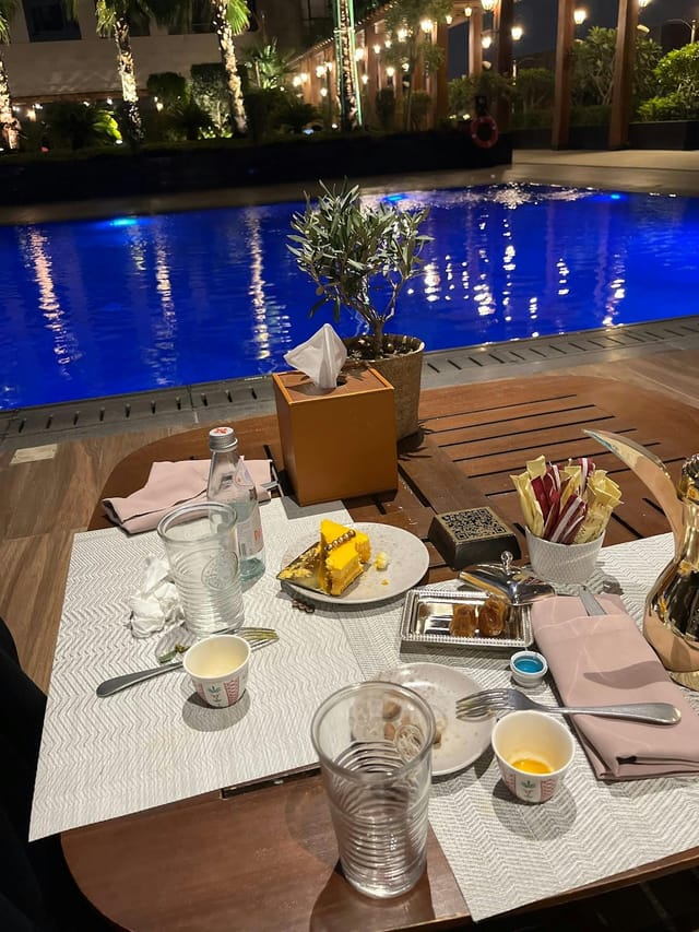 Unserviced VIP poolside event bar with cluttered tabletops; luxury event cleanup, post-event care.