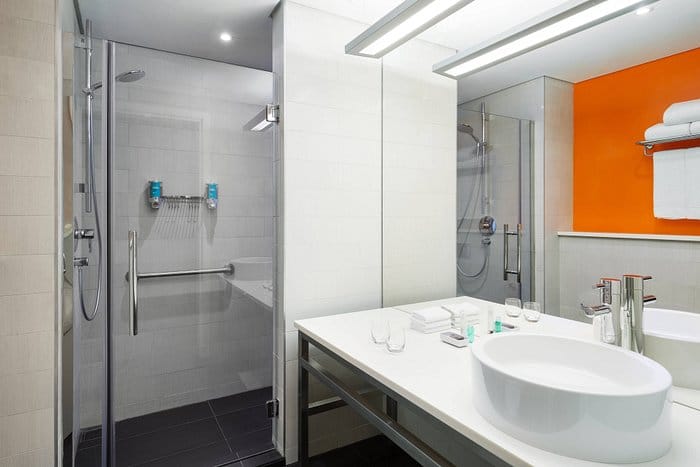 Accessible hotel bathroom in Aloft Riyadh with walk-in shower for conference hotel accommodations.