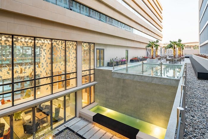 Corporate event space at Park Inn Riyadh featuring indoor-outdoor networking area and lobby.