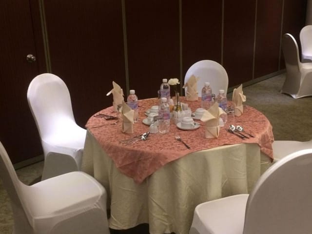Cramped breakout room setup with uneven linens at Executives Hotel Al Azizia for corporate events.