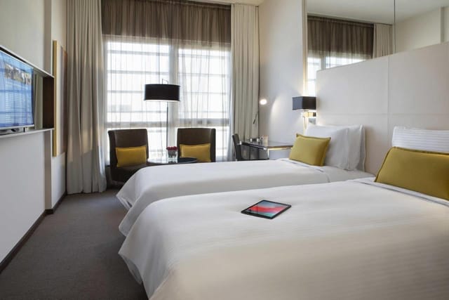 Twin-bedded corporate room at Centro Waha featuring modern workspace for business travel.