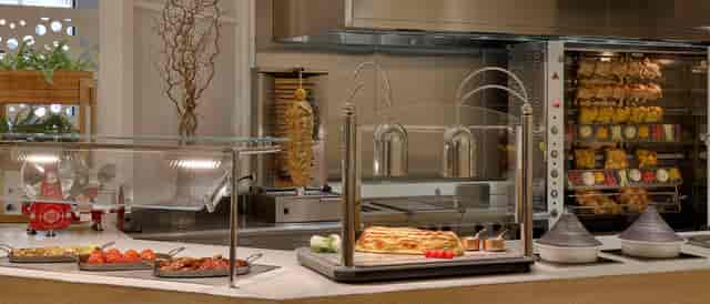 Patras hotel buffet station with rotisserie for theater-style catering and luxury event dining.