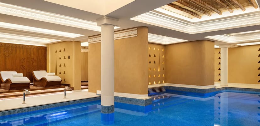 Luxury indoor pool at Jareed Bab Samhan hotel for corporate wellness event or conference breakout.