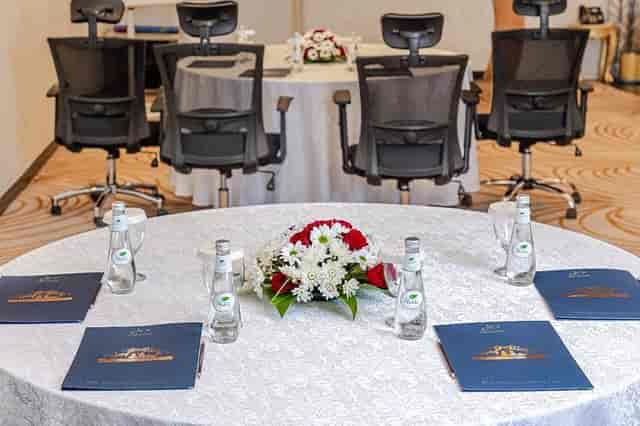 Madareem Hotel boardroom suite with round tables and mesh chairs for corporate business meetings.