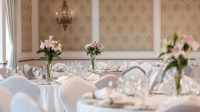 Elite banquet hall with elegant floral centerpieces for formal events and luxury weddings.