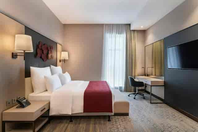 Modern guest room with ergonomic workstation at Ramada Riyadh for business travel and meetings.