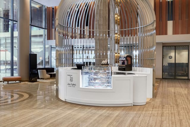 Branded coffee kiosk in Radisson Blu Riyadh exhibition hall for corporate networking events.