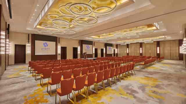 Al Loulou’a Ballroom with orange chairs, ideal for corporate conferences in Riyadh.