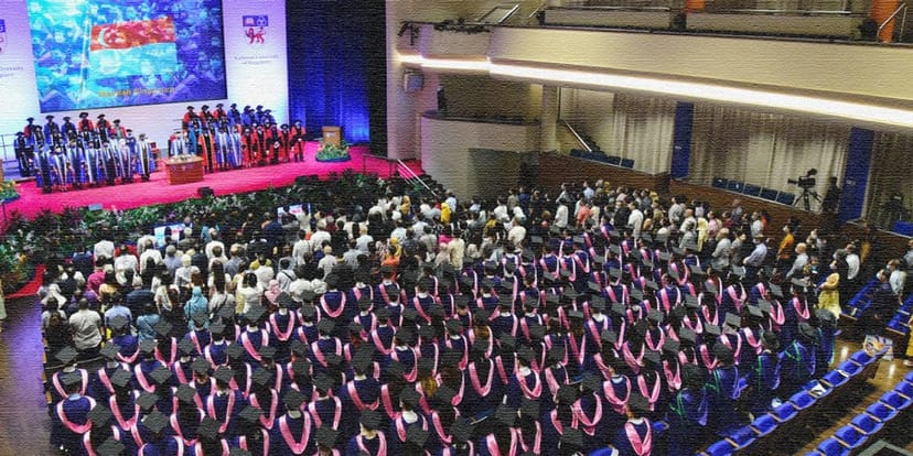 Commencement ceremony in tiered auditorium for large-scale academic event.