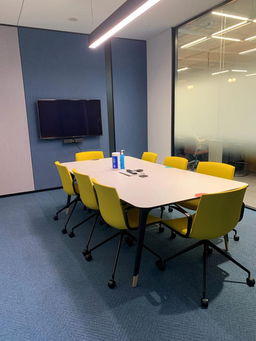 Tech-enabled huddle room with wall display for professional hybrid meetings and agile collaboration.