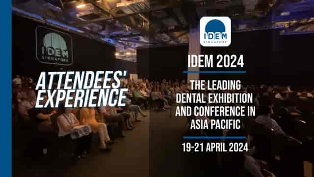Theater-style breakout session at IDEM 2024 conference, crowded audience in a dark-box hall.
