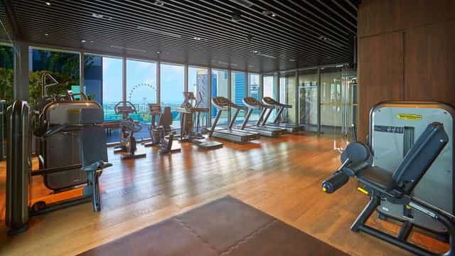 Luxury hotel fitness center with skyline view for corporate wellness and business travel.