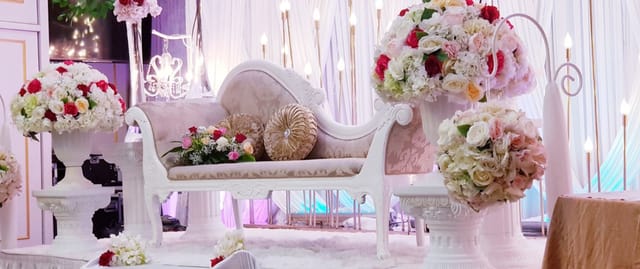 Red Velvet Ballroom wedding sweetheart stage with floral decor and chaise lounge for luxury events.