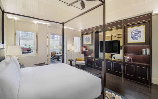 Luxury hotel suite with four-poster bed for VIP speaker accommodations and executive events.