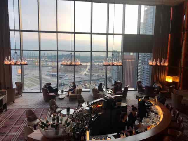 Modern hotel bar with floor-to-ceiling windows, ideal for networking events and VIP receptions.