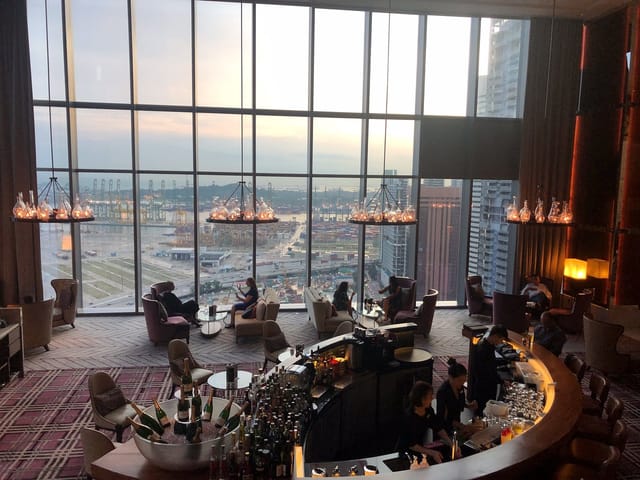 Modern hotel bar with floor-to-ceiling windows, ideal for networking events and VIP receptions.