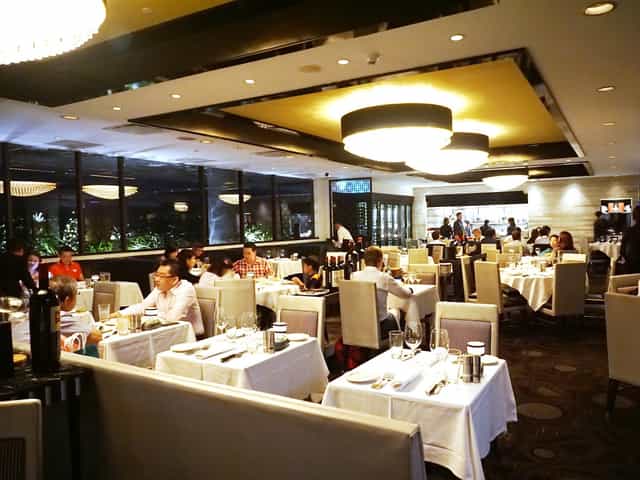 Morton's Steakhouse dining room with white linen for corporate dinners and VIP networking events.