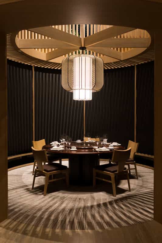 Private dining room with architectural light fixture for executive board meetings and VIP dinners.